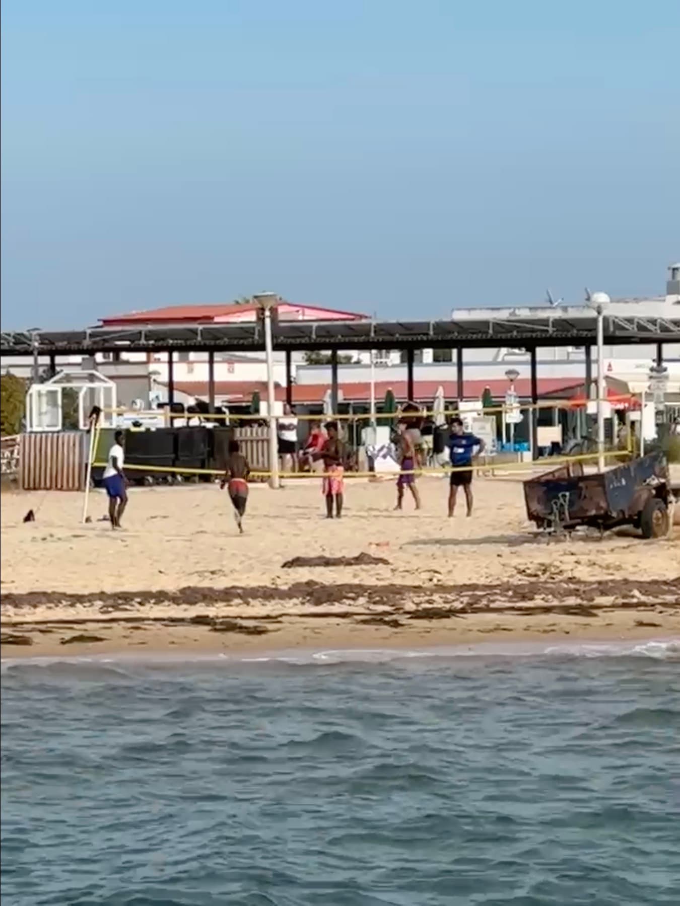 A game of beach football on the sand at Olhão, seen from the water, with a marker pointing out the writer in a blue shirt.